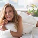 Hilarious smiling young woman in bed