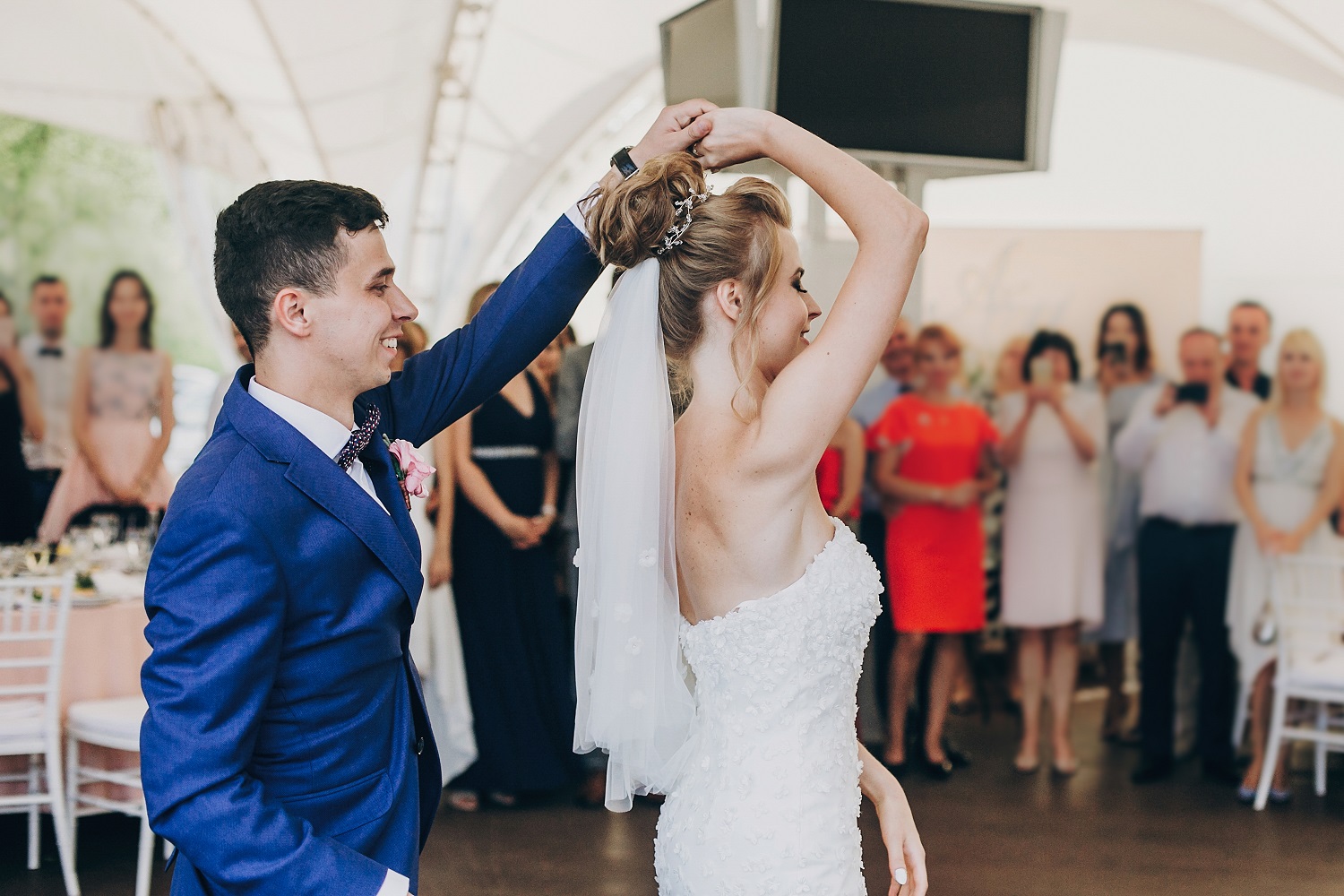 Stylish happy bride and groom gently dancing at wedding receptio