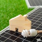 Wooden house miniature and solar panel close up