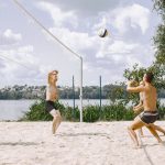 Young people playing volleyball on the beach