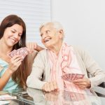 Junge Frau und Seniorin beim Karten spielen
